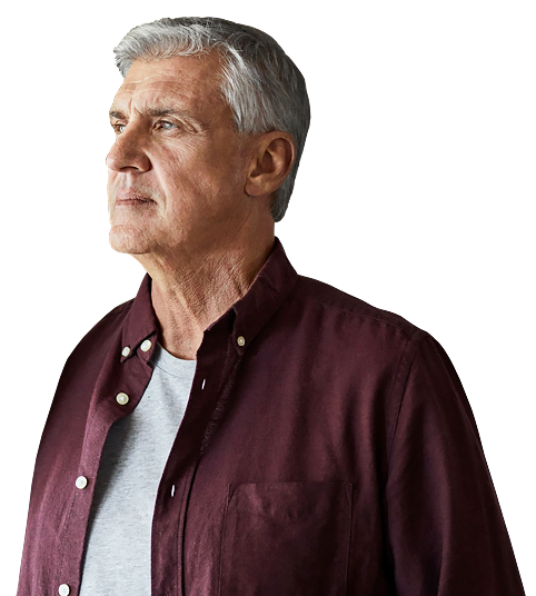 A man wearing a collared shirt over his undershirt looking into the distance